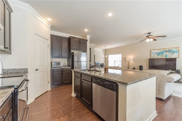 a kitchen with stainless steel appliances granite countertop a sink stove and refrigerator