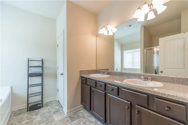 a bathroom with a granite countertop sink a light fixture and a mirror