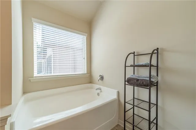 a bathroom with a bathtub and next to a window