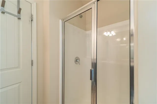 a bathroom with a glass shower door and a glass door