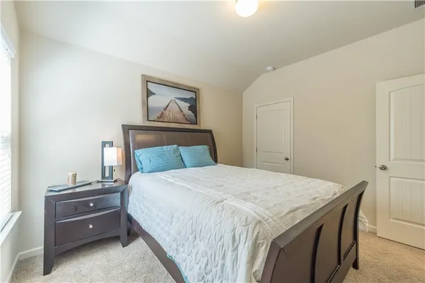 a bedroom with a bed and a painting on the wall