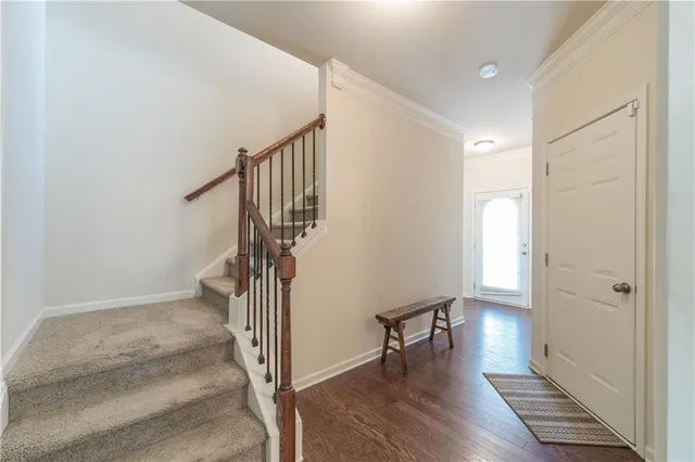 a view of a hallway with wooden floor and stairs