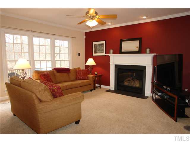 2808 Sunnystone Way Raleigh, NC 27613 - Photo 7 of 21 a living room with furniture a flat screen tv and a fireplace