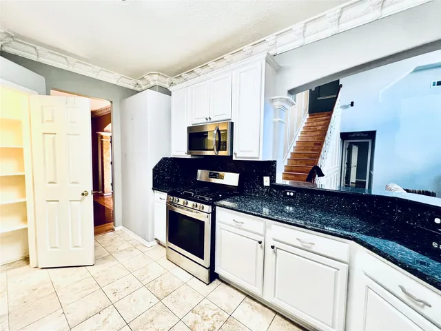 a kitchen with stainless steel appliances granite countertop a sink and a stove