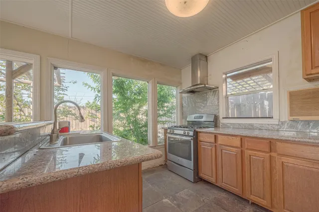 a kitchen with granite countertop a sink and white cabinets