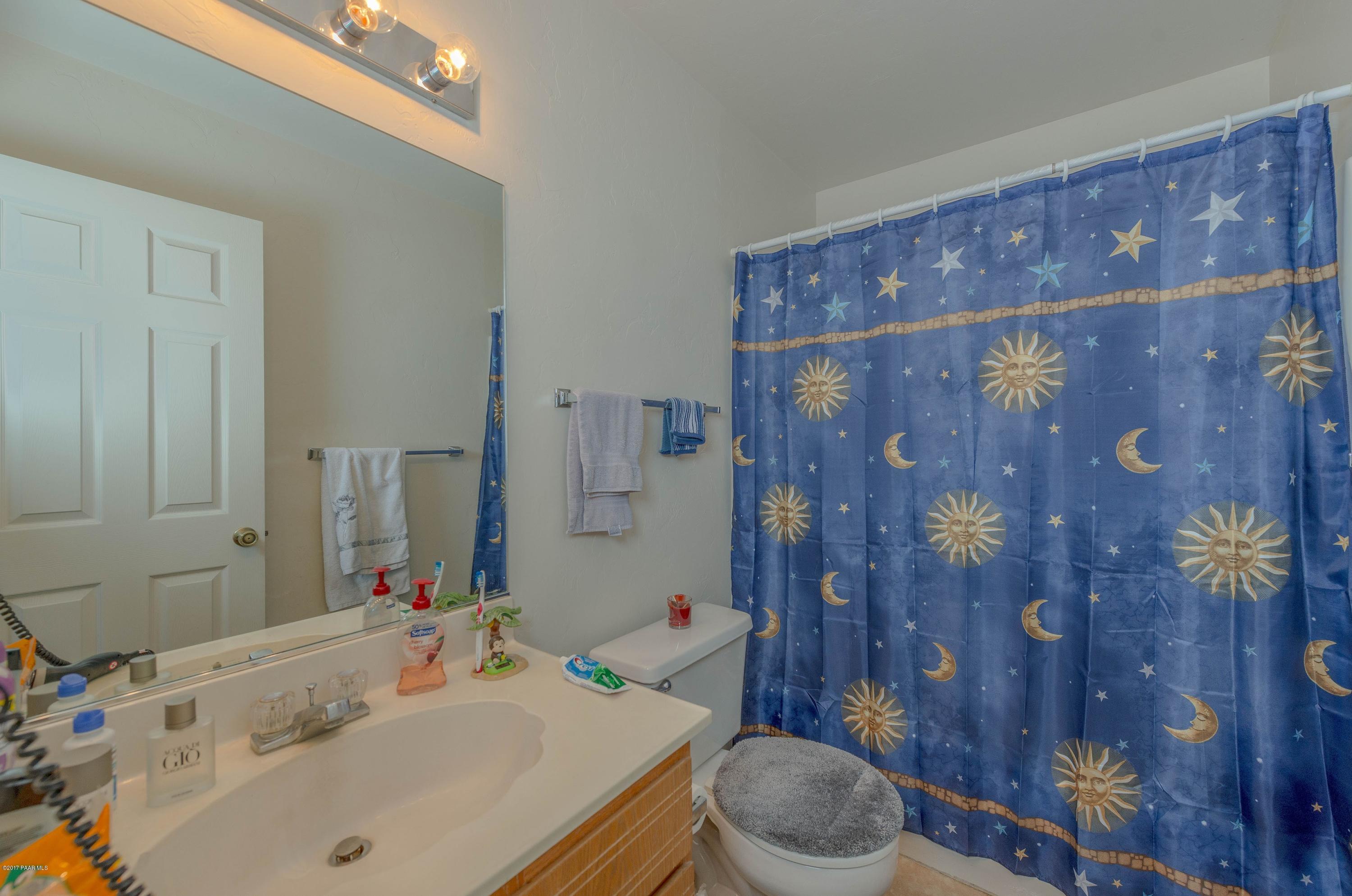 3265 North Yavapai Road East Prescott Valley, AZ 86314 - Photo 12 of 19 a bathroom with a sink a toilet and shower curtain