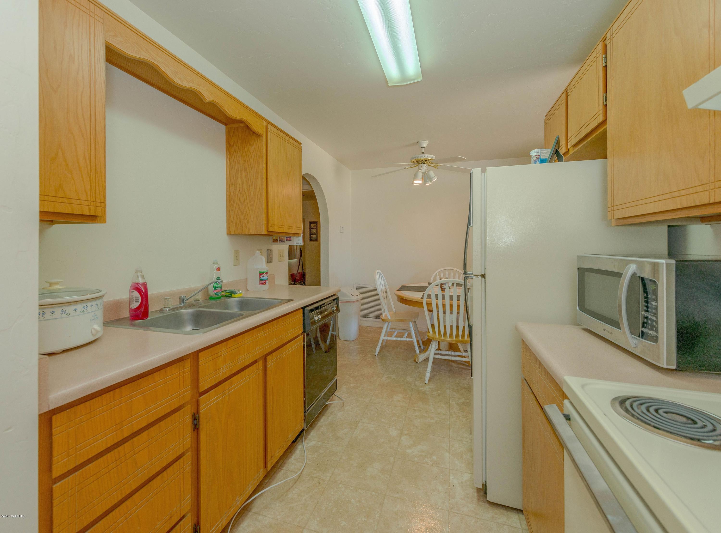 3265 North Yavapai Road East Prescott Valley, AZ 86314 - Photo 7 of 19 a kitchen with granite countertop a sink stove and cabinets