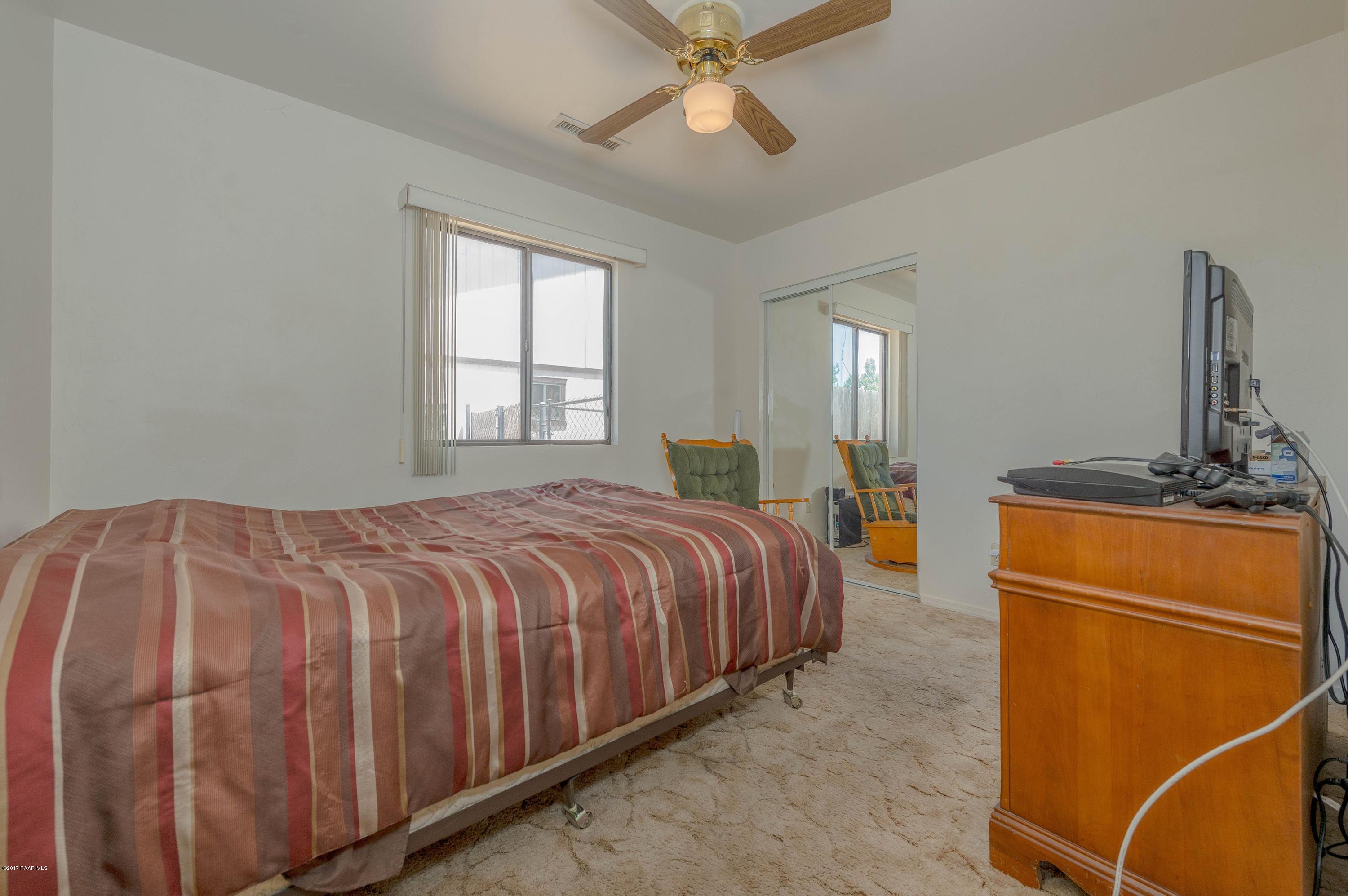 3265 North Yavapai Road East Prescott Valley, AZ 86314 - Photo 10 of 19 a bedroom with a bed and a chandelier