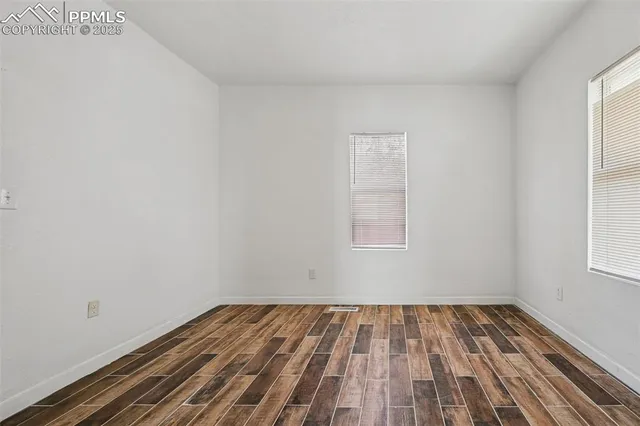 a view of a room with wooden floor and window