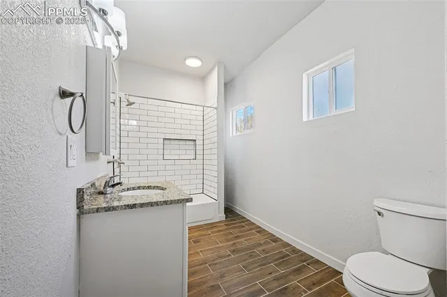 a bathroom with a granite countertop sink toilet and shower