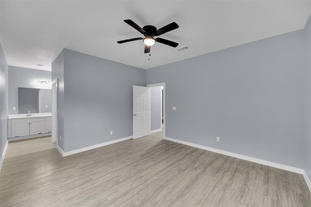 409 Dallas Street Rice, TX 75155 - Photo 13 of 26 an empty room with wooden floor and ceiling fan