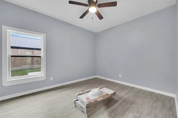 an empty room with a window and ceiling fan