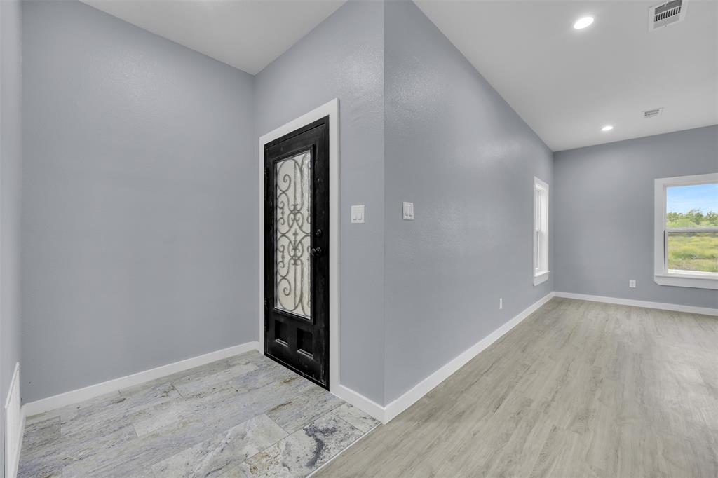 409 Dallas Street Rice, TX 75155 - Photo 5 of 26 an empty room with wooden floor and windows