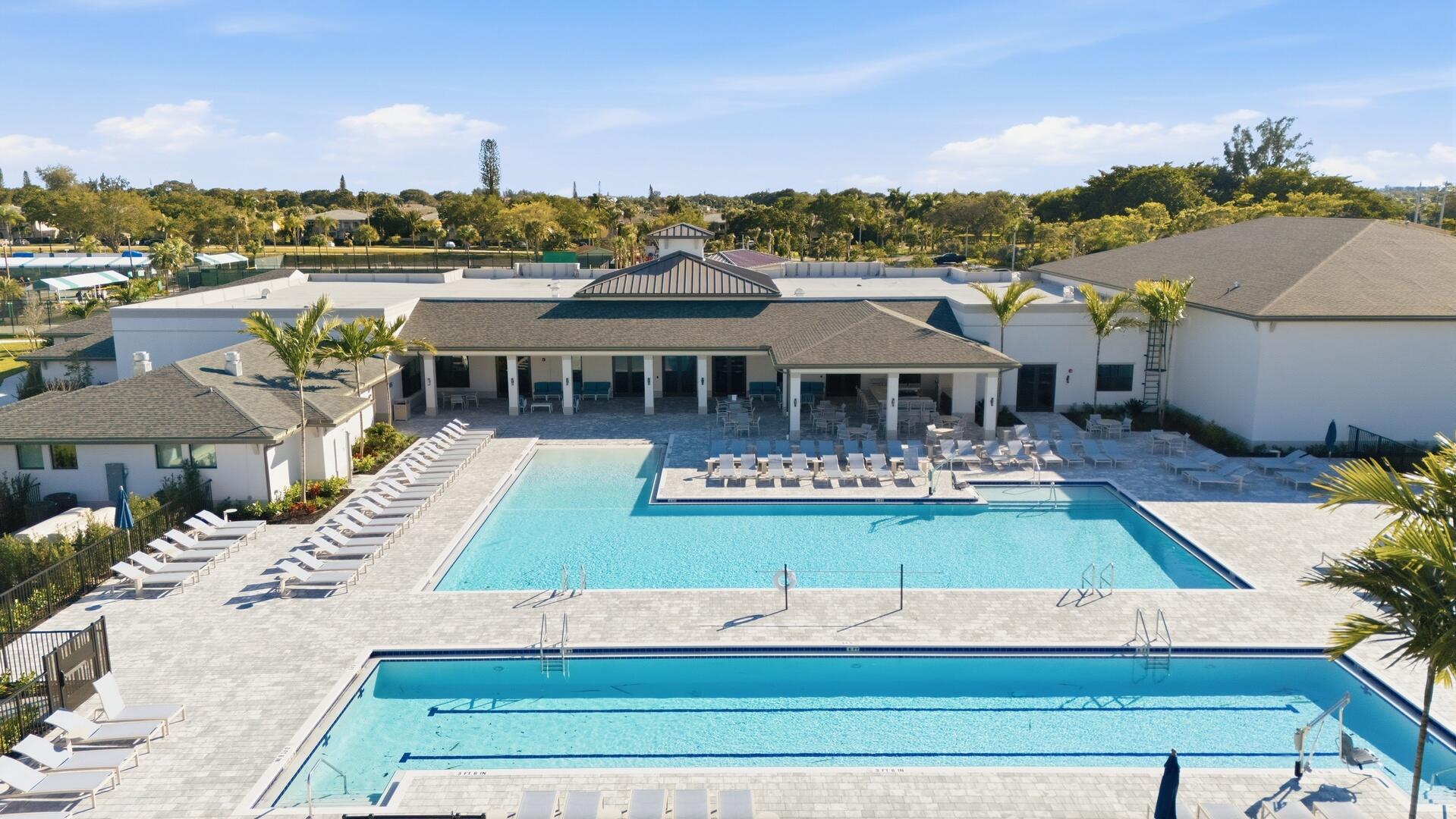 13670 Vía Flora, Unit B Delray Beach, FL 33484 - Photo 31 of 36 a view of a house with pool lawn chairs and a yard
