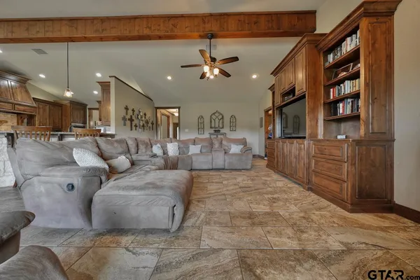 a living room with furniture a ceiling fan and a rug