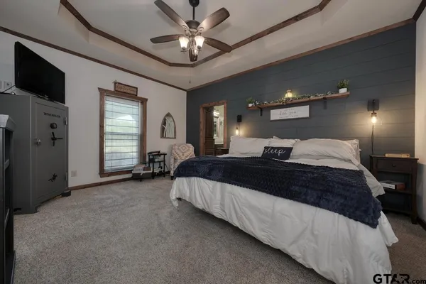 a spacious bedroom with a large bed and a chandelier