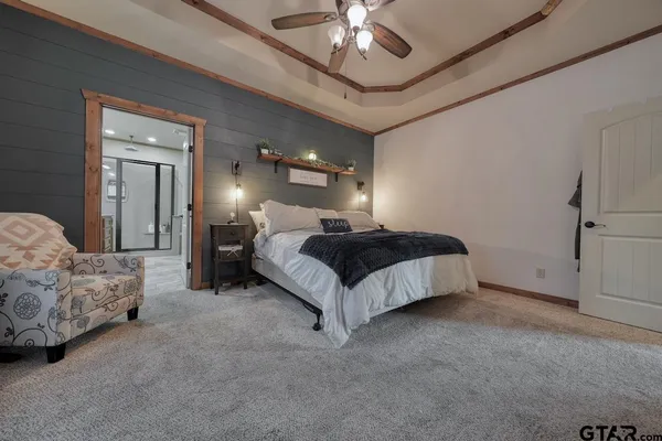 a spacious bedroom with a bed couch and chandelier