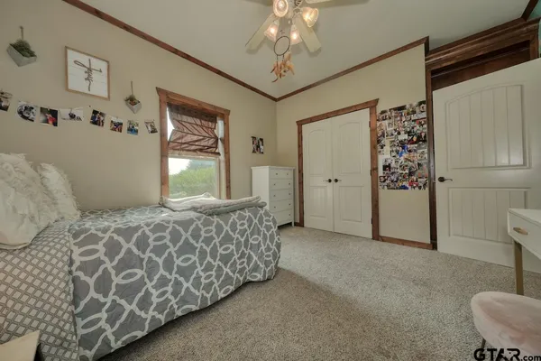 a spacious bedroom with a bed and a chandelier