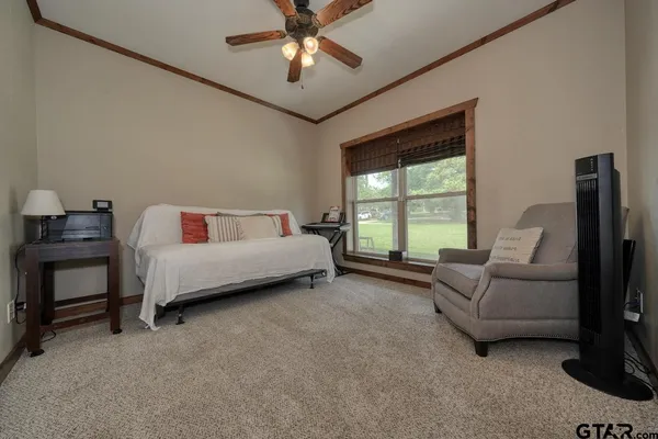 a bedroom with a bed a couch and a chandelier