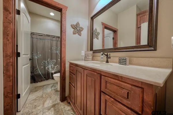 a bathroom with a sink a mirror a vanity and a shower