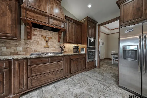 a kitchen with granite countertop stainless steel appliances and wooden cabinets