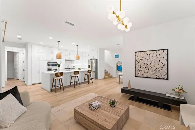 a kitchen with stainless steel appliances a dining table chairs and white cabinets