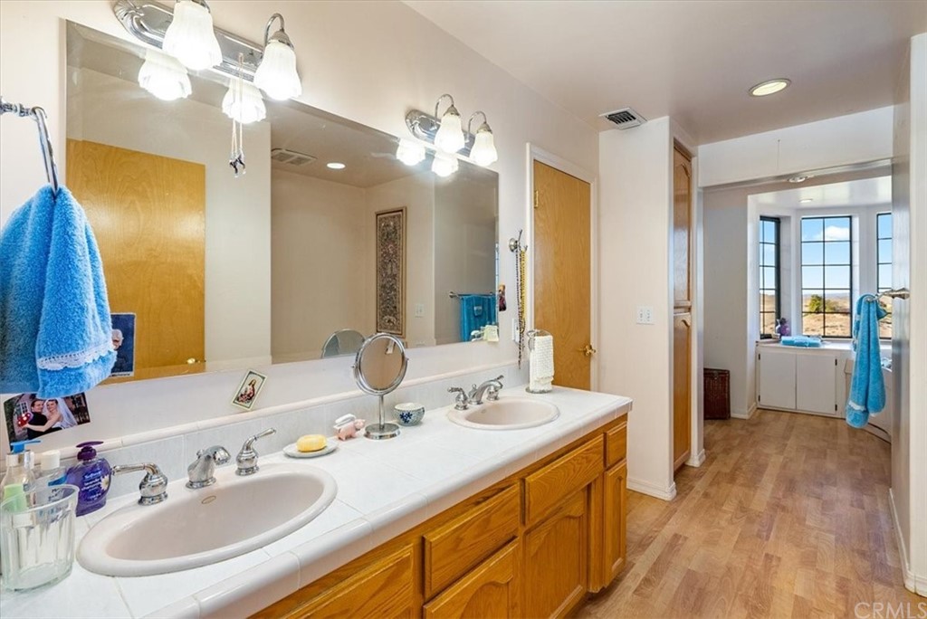 8700 Bee Tree Road Paso Robles, CA 93446 - Photo 31 of 74 a bathroom with a double vanity sink and a mirror