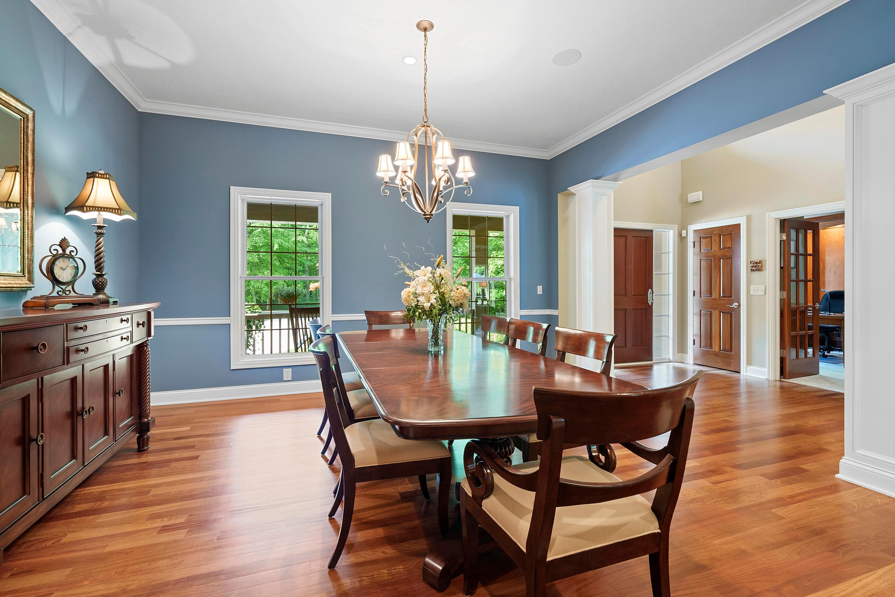 5761 Hughes Road Galena, OH 43021 - Photo 12 of 43 – Elegant formal Dining Room designed for gracious entertaining and family celebrations. The room features Brazilian cherry flooring, an open design with four architectural accent columns, 10’ ceiling with chandelier, crown molding & chair rail, built-in sound system speakers