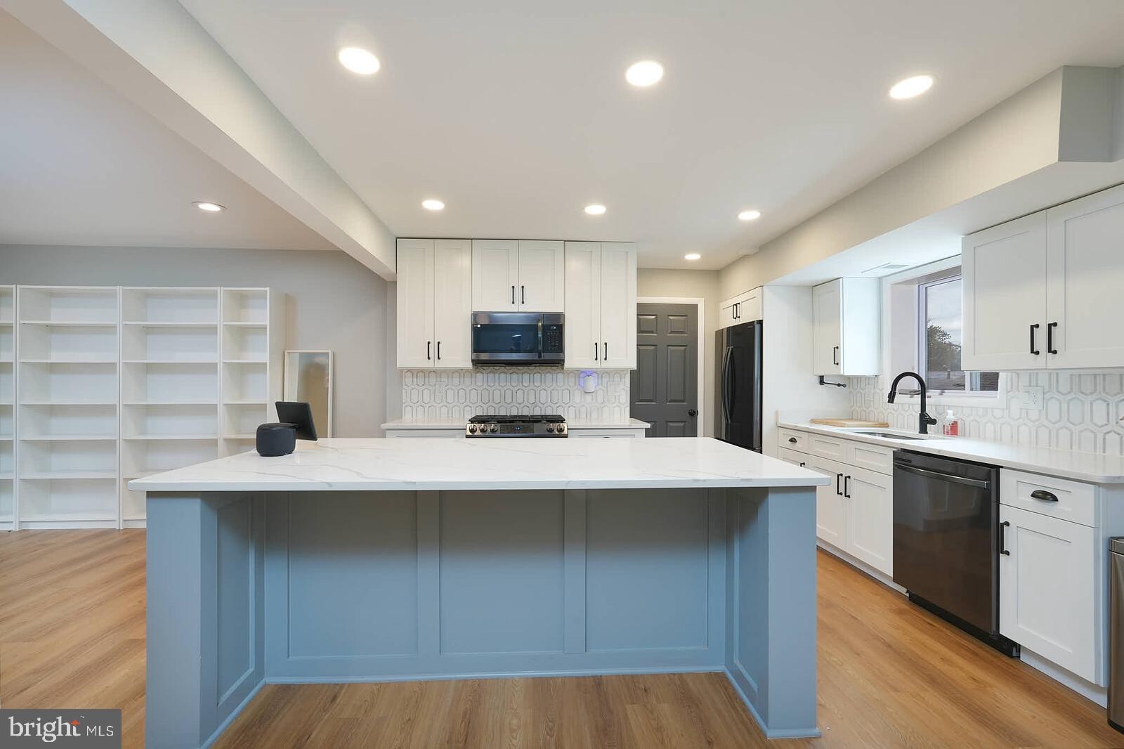 2425 Skyland Place Southeast Washington, DC 20020 - Photo 7 of 41 a kitchen with stainless steel appliances a sink a stove a refrigerator cabinets and a center island
