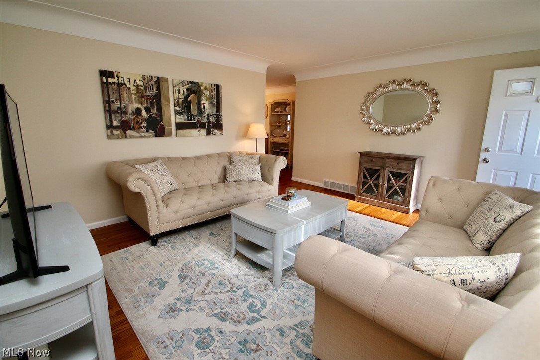 Beautiful and spacious living room with refinished wood floors and fresh neutral paint.