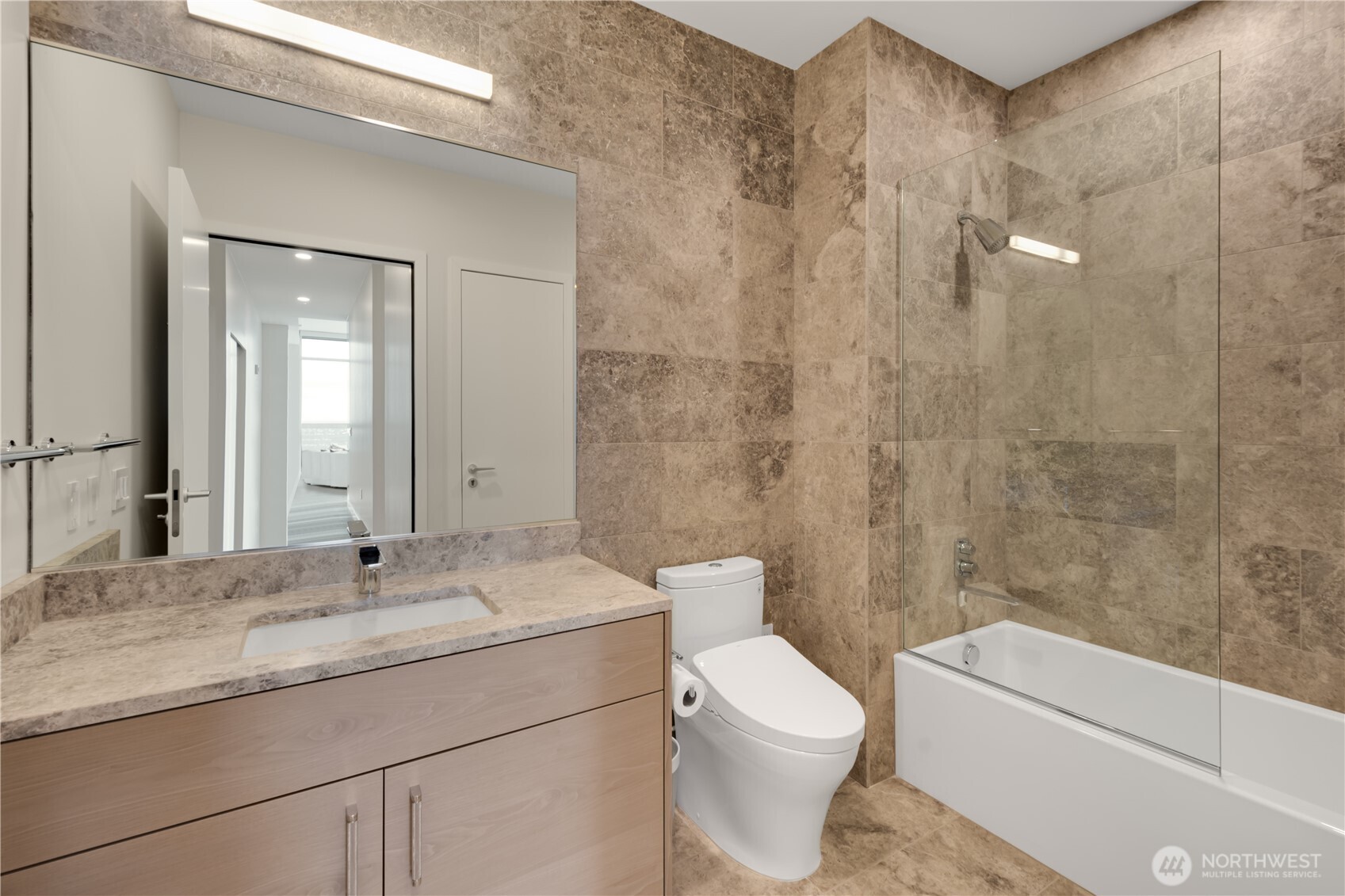 121 Stewart Street, Unit 3504 Seattle, WA 98101 - Photo 22 of 31 a bathroom with a granite countertop sink a toilet and shower