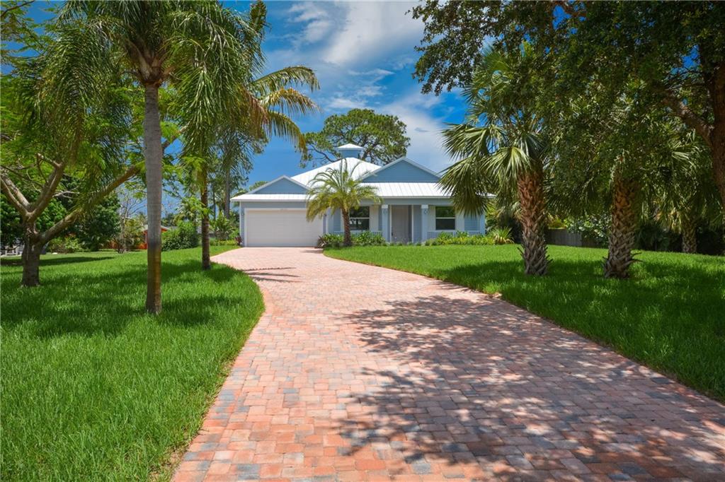 2035 Northwest Fork Road Stuart, FL 34994 - Photo 29 of 37 a view of a white house with a big yard and potted plants and large trees