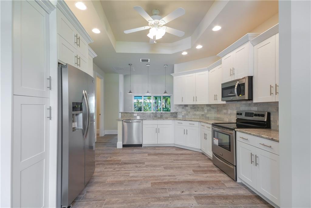 2035 Northwest Fork Road Stuart, FL 34994 - Photo 3 of 37 a large kitchen with cabinets stainless steel appliances a window and a sink