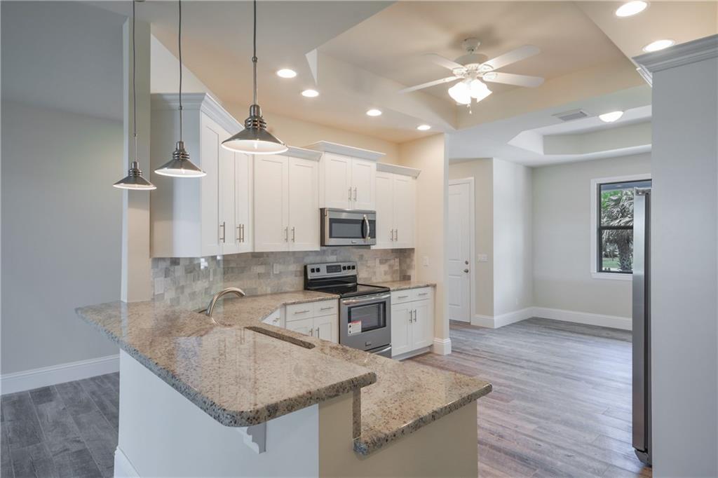2035 Northwest Fork Road Stuart, FL 34994 - Photo 4 of 37 a kitchen with stainless steel appliances granite countertop a sink a stove and a refrigerator