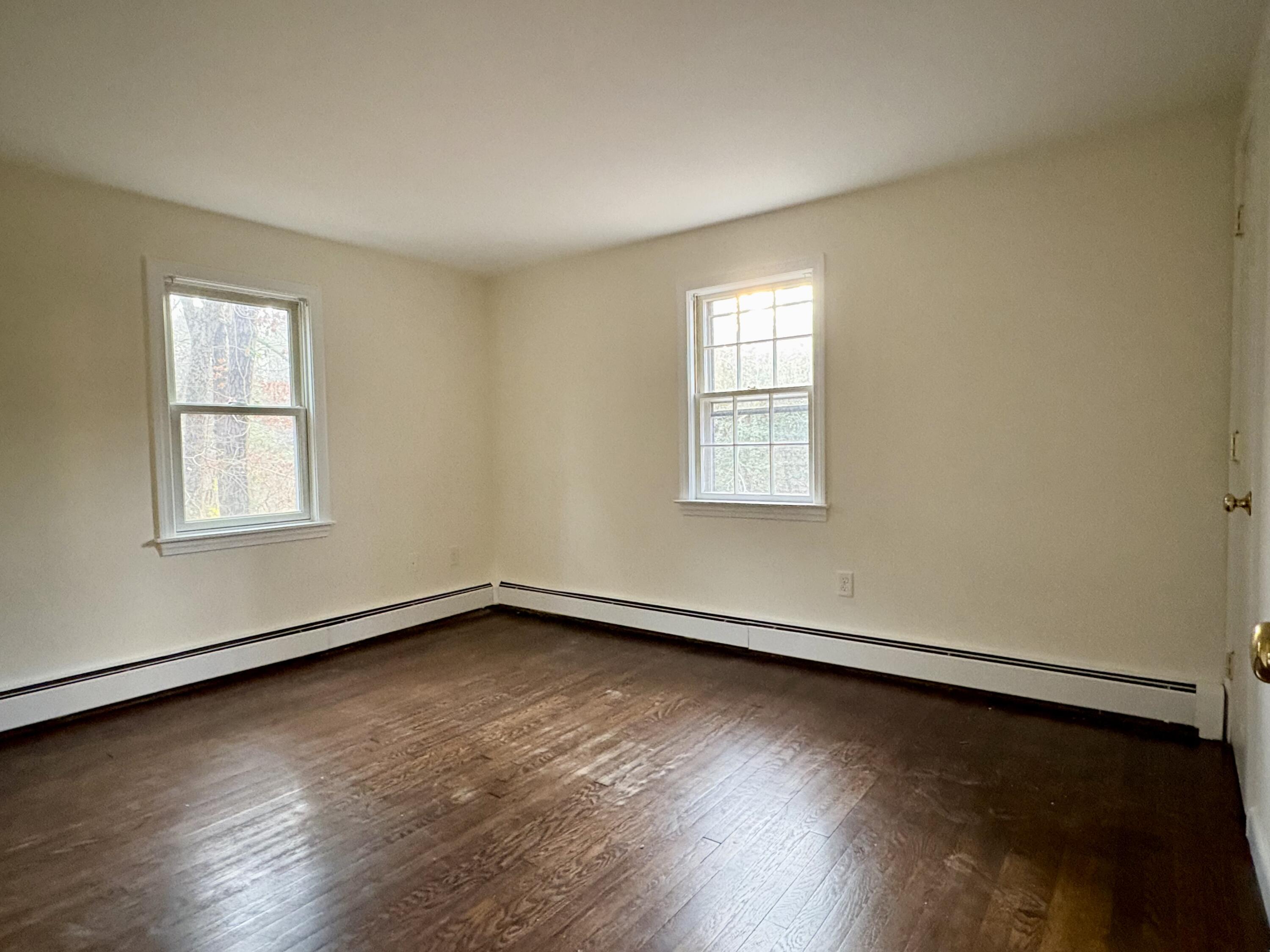55 Chickadee Lane Centerville, MA 02632 - Photo 18 of 26 an empty room with wooden floor and windows
