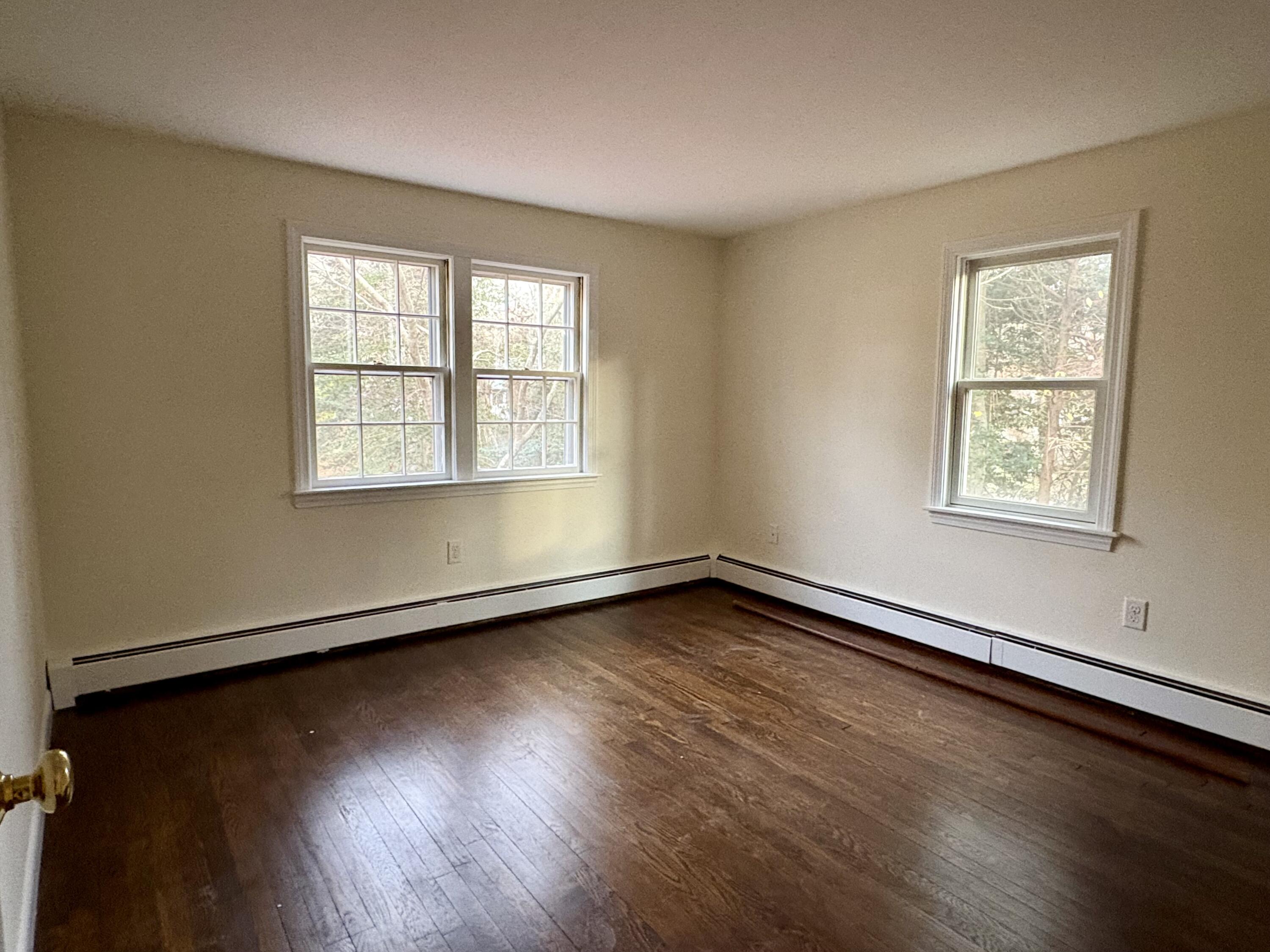 55 Chickadee Lane Centerville, MA 02632 - Photo 20 of 26 an empty room with wooden floor and windows