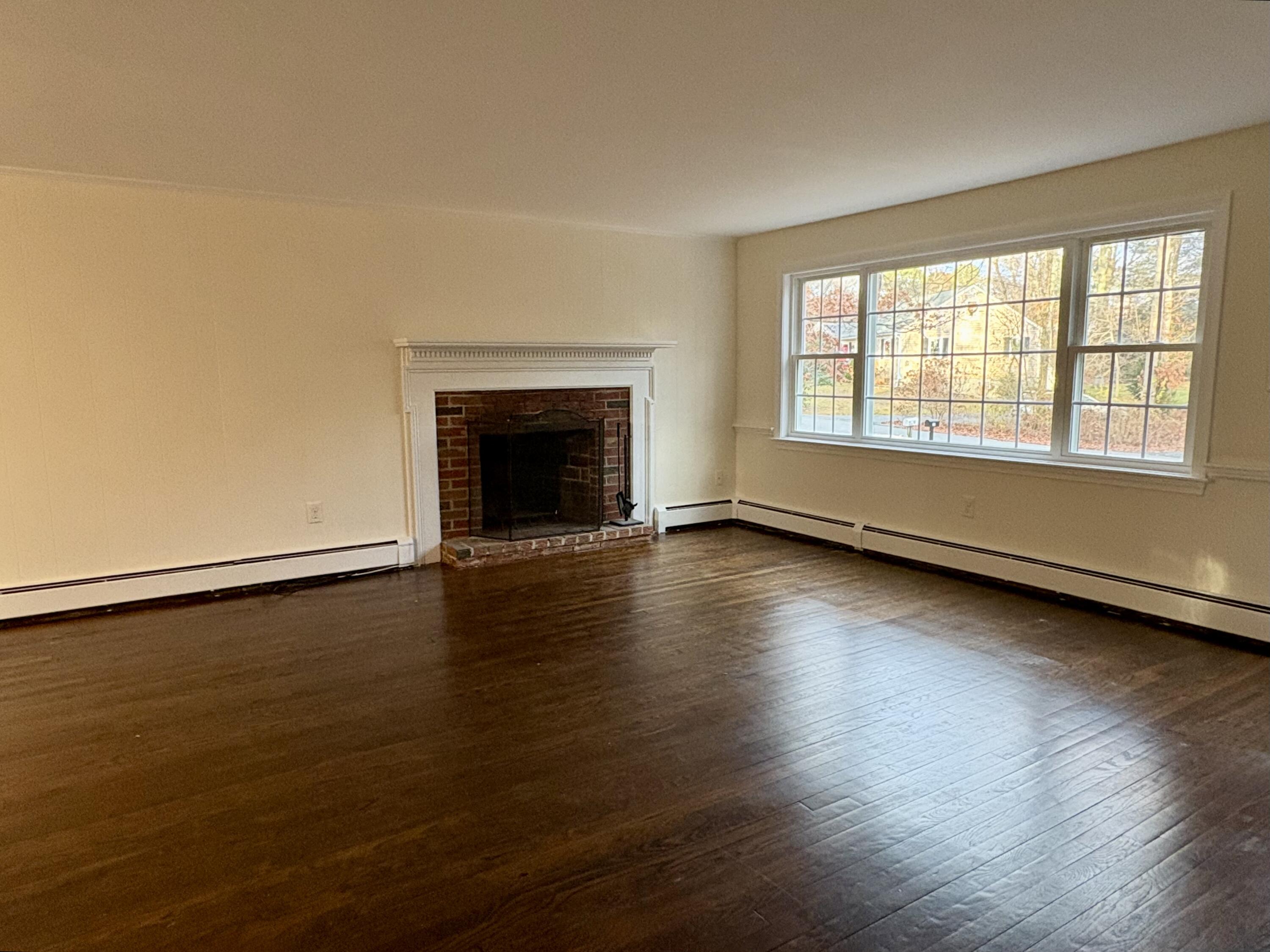 55 Chickadee Lane Centerville, MA 02632 - Photo 5 of 26 a view of empty room with wooden floor and fireplace
