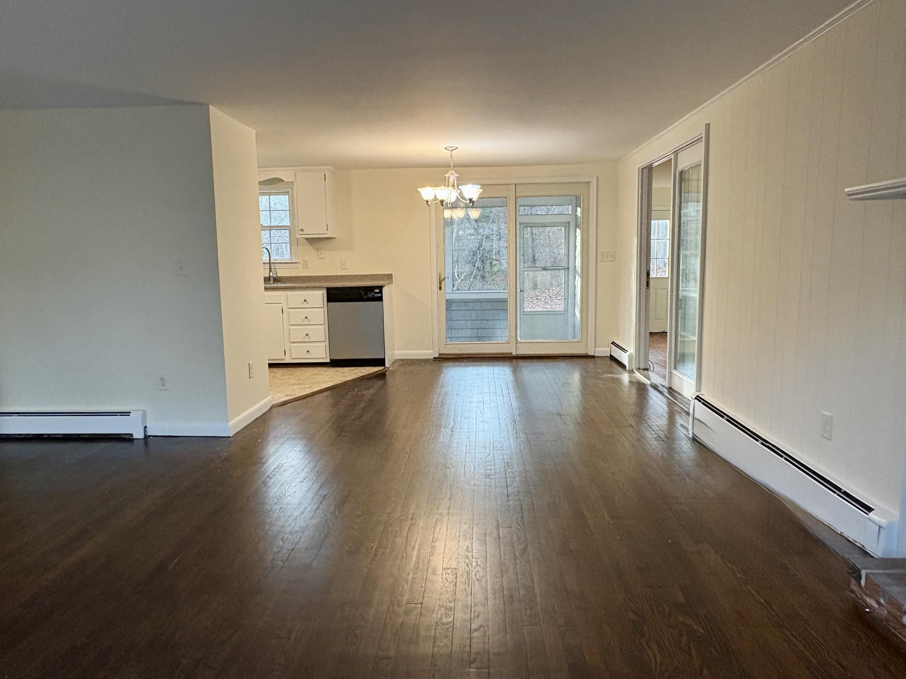 55 Chickadee Lane Centerville, MA 02632 - Photo 7 of 26 a view of an empty room with a window and wooden floor