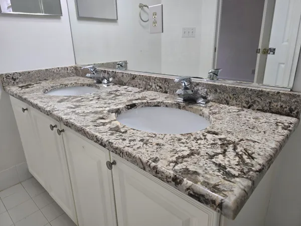 a bathroom with a granite countertop sink and a mirror