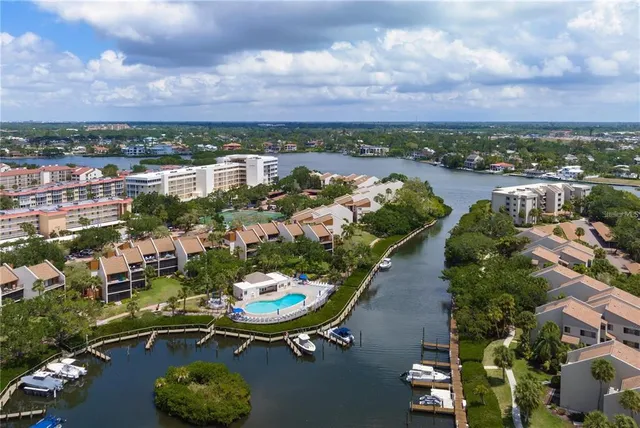 an aerial view of a city with lots of residential buildings ocean and mountain view in back