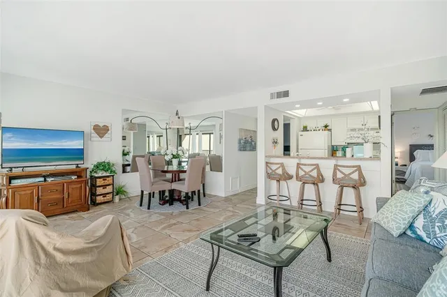 a living room with fireplace furniture and a view of kitchen