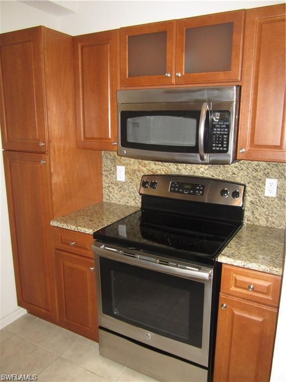 8560 Violeta Street, Unit 104 Estero, FL 34135 - Photo 4 of 12 a stove top oven sitting inside of a kitchen