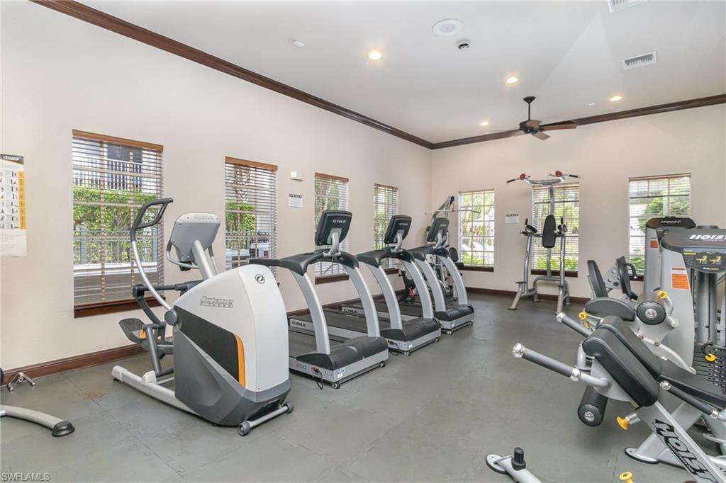 8560 Violeta Street, Unit 104 Estero, FL 34135 - Photo 9 of 12 a spacious bedroom with a bed a table and windows