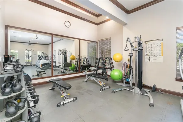 a room with gym equipment and large mirror