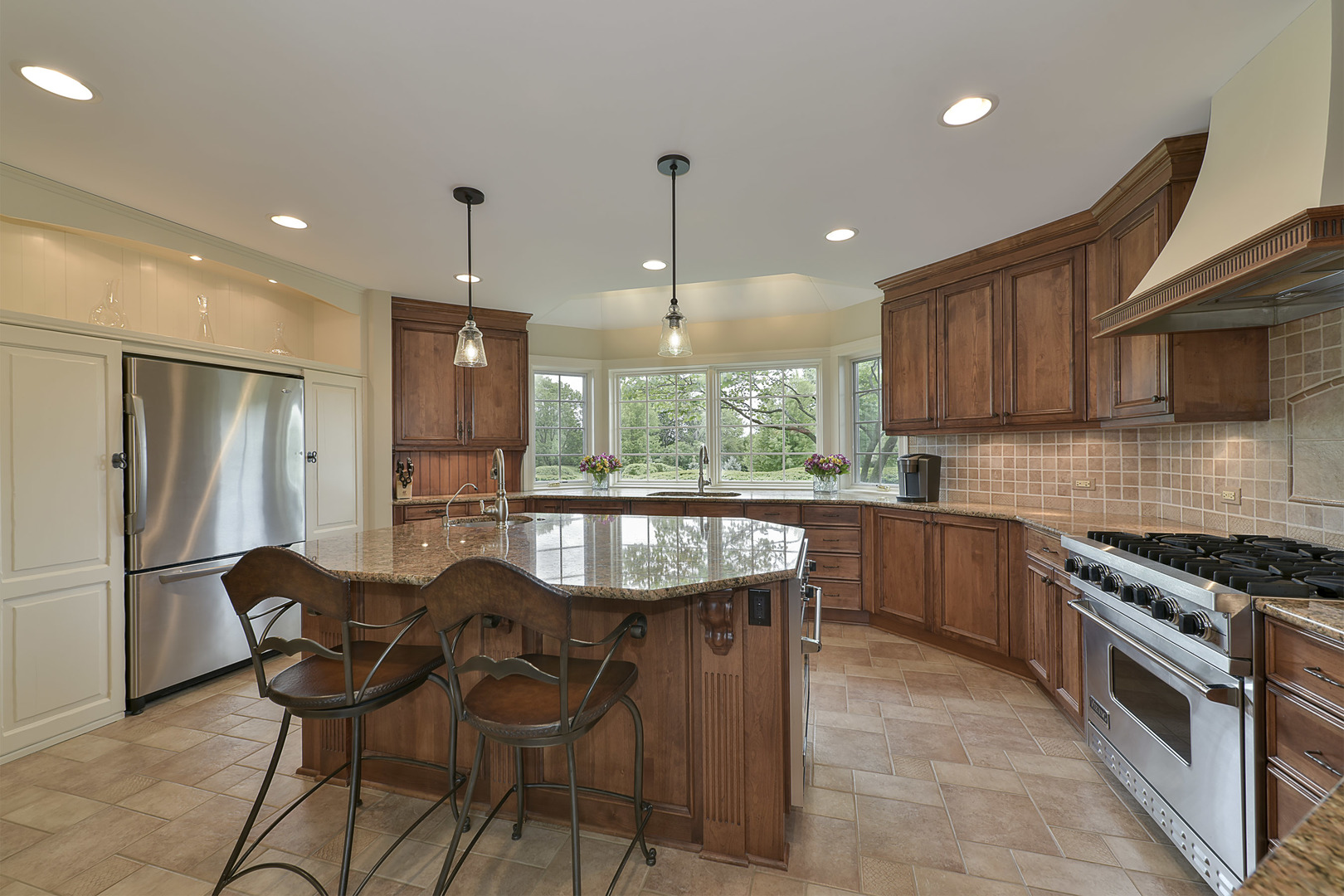1720 Firth Road Inverness, IL 60067 - Photo 4 of 34 a kitchen with stainless steel appliances granite countertop a stove a sink a microwave a refrigerator and chairs