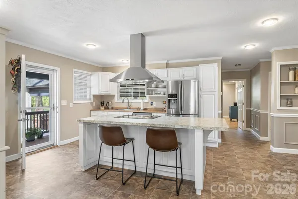a kitchen with stainless steel appliances a dining table chairs and wooden cabinets