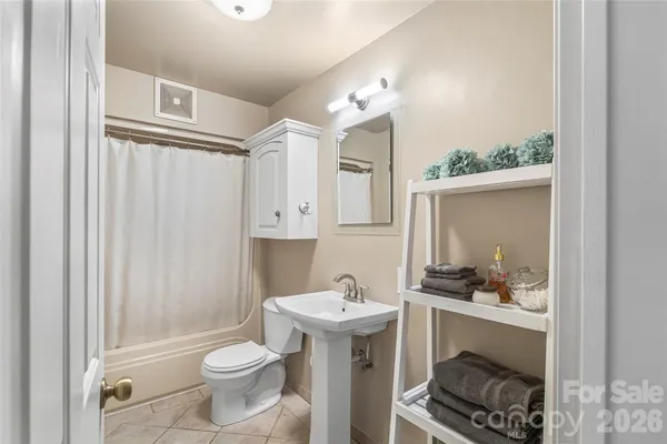 a bathroom with a sink a toilet a mirror and shower