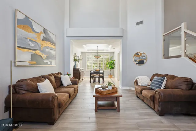 a dining room with furniture potted plants and a chandelier