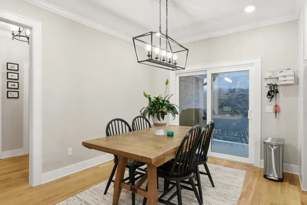 a view of a dining room with furniture a chandelier and wooden floor