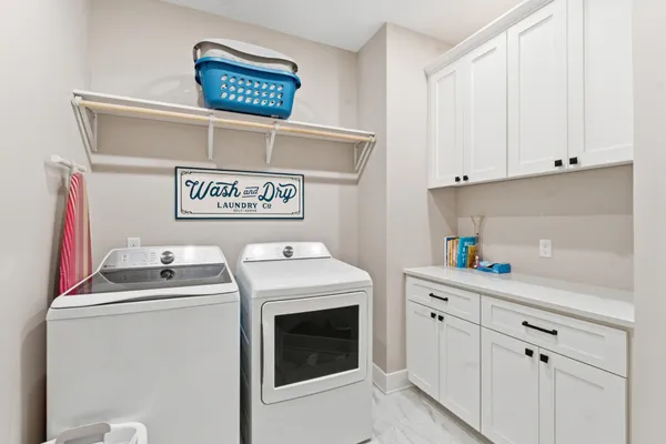 a utility room with dryer washer and sink